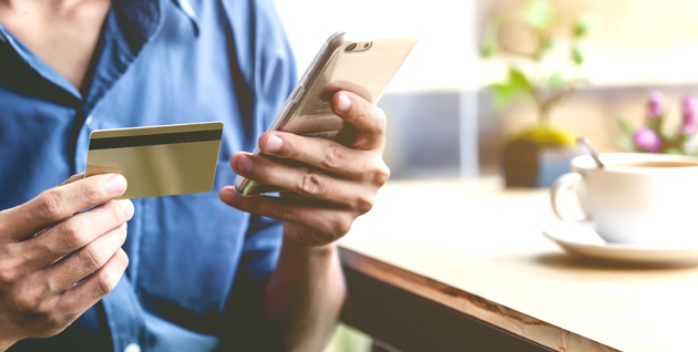 Man holding mobile ph and a card